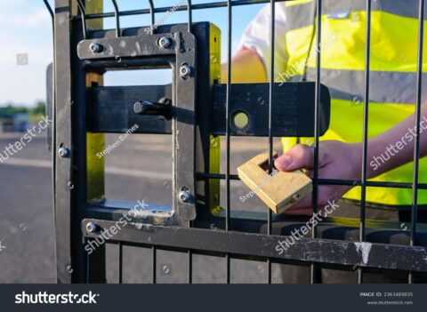 Stock Photo A Security Guard Attaches A Lock To A Gate After Unlocking The Bolt And Opening The Gate 2363489835